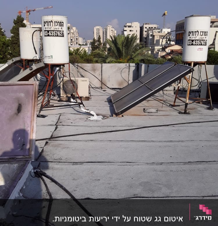 גג עם יריעות איטום, דודי שמש וצינורות.